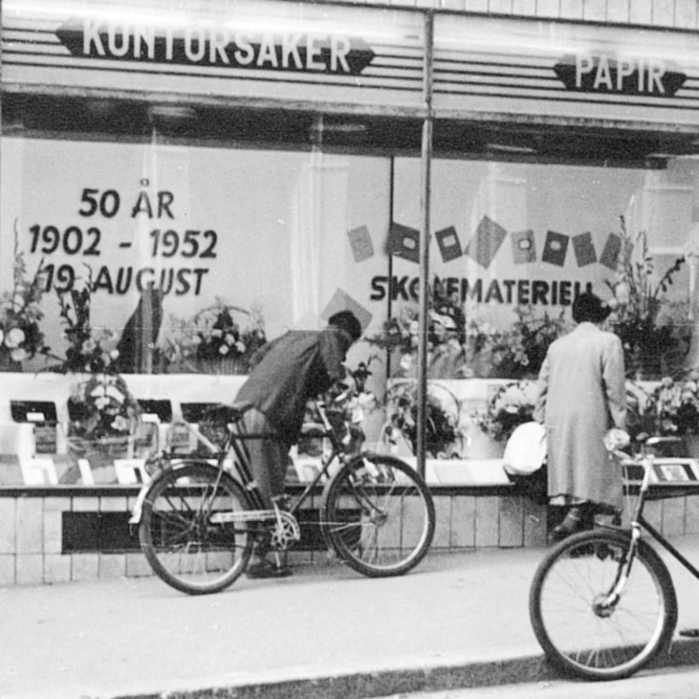 Mann på sykkel foran bokhandelen i anledning 50 års jubileum. 